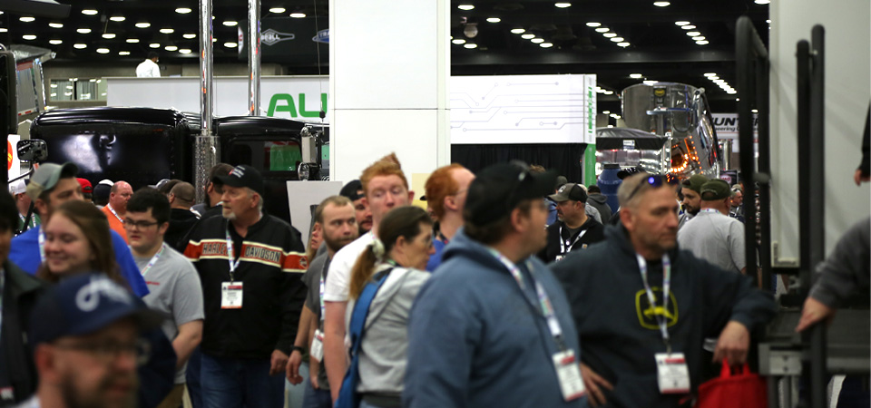 Crowds exploring trucks and exhibits at the Mid-America Trucking Show.